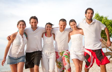 Group of friends having fun and smiling at the beach
