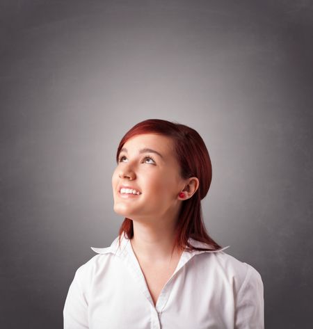 Beautiful young woman standing and thinking with copy space