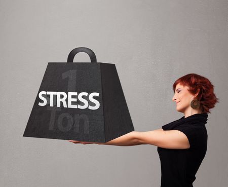 Attractive young woman holding one ton of stress weight