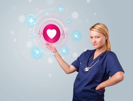 Young nurse standing and pressing modern medical type of buttons