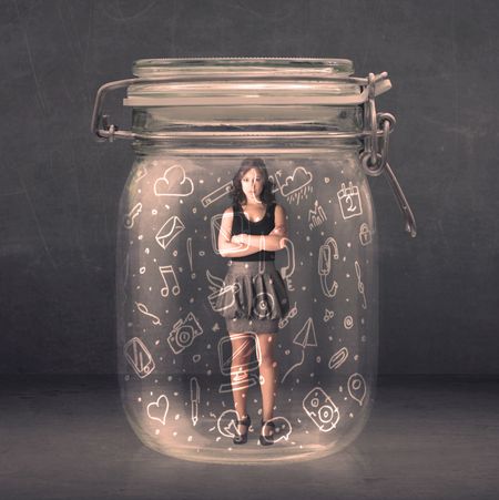 Business woman captured in glass jar with hand drawn media icons concept on background