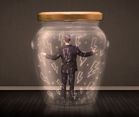 Businessman inside a glass jar with lightning drawings concept on background