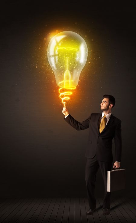 Businessman holding a shining idea bulb