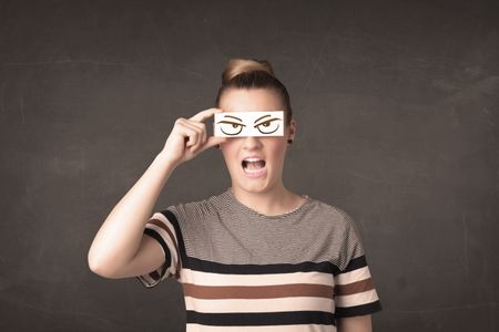 Young person holding paper with angry eye drawing concept