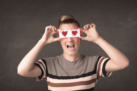 Pretty girl holding paper with red heart drawing concept