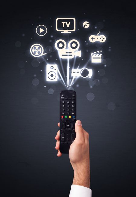Hand holding a remote control, media icons coming out of it 