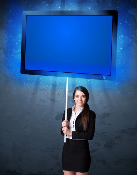 Young businesswoman holding a big, blue shining tablet 