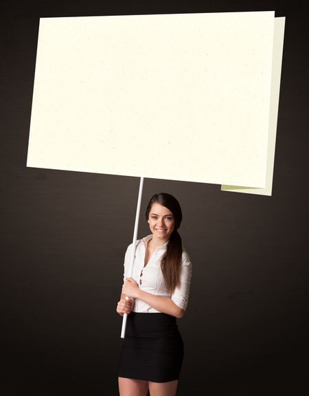 Young businesswoman holding a big, white post-it paper 
