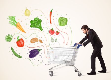 Businessman pushing a shopping cart and healthy vegetables coming out of it 