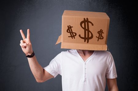 Young man standing and gesturing with a cardboard box on his head with dollar signs