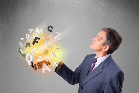 Middle aged businessman in suit holding laptop with colorful letters