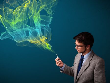 Handsome young man smoking cigarette with colorful smoke
