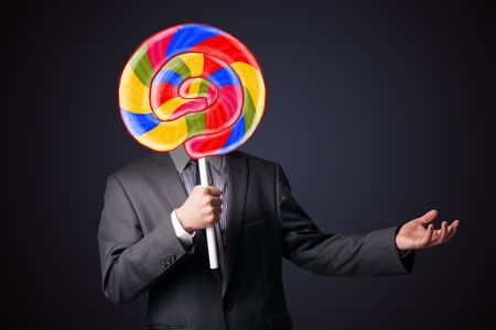 Businessman holding a colorful striped lollipop in front of his head