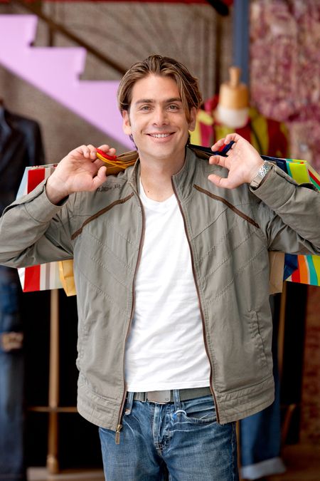 Male shopper holding some paper bags at a retail store