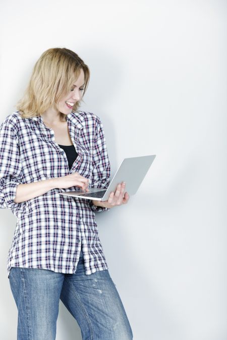 Attractive young woman holding a laptop computer smiling