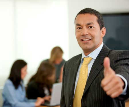 business man portrait in an office with thumbs up