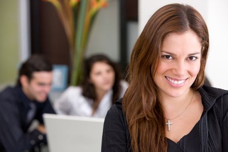 Businesswoman in an office with her team behind her