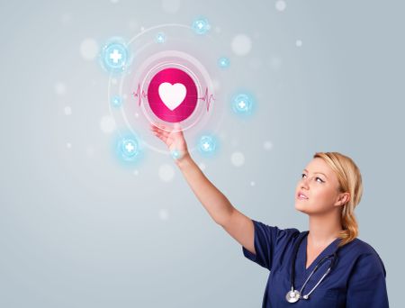 Young nurse standing and pressing modern medical type of buttons