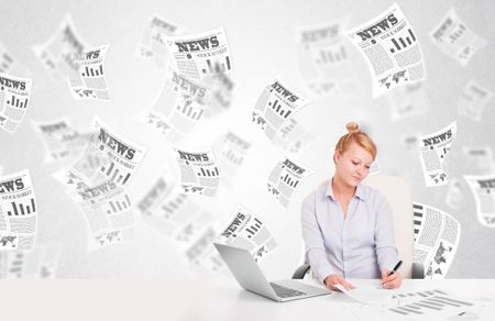 Business woman at desk with stock market newspapers concept