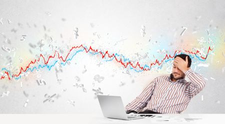 Business man sitting at table with stock market graph 3d letters