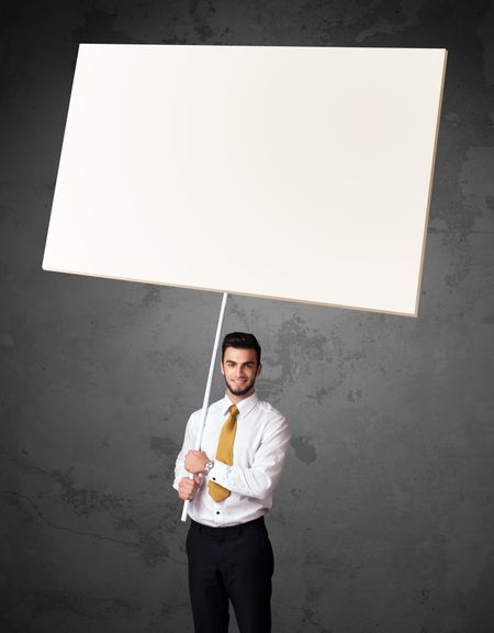 Young businessman holding a blank whiteboard