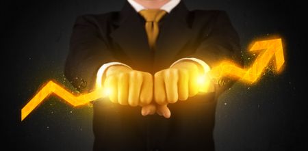 Business person holding a hot glowing upright arrow concept on background