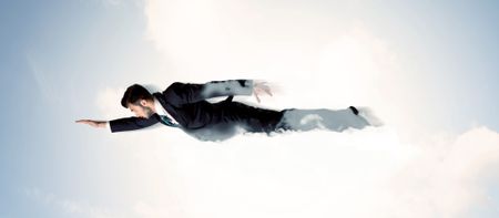 Business man flying like a superhero in clouds on the sky concept