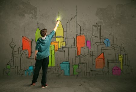 Young urban painter drawing colorful city  on the wall