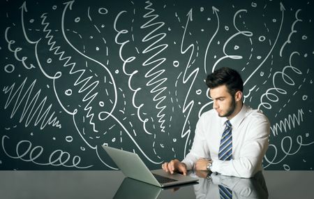 Businessman sitting at table with drawn curly lines and arrows on the background 