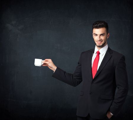 Businessman standing and holding a white cup on a black background