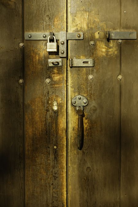 Detail of antique wooden door with padlock and hardware on restored Victorian house built in 1858 and now maintained as a public museum