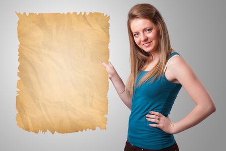Beautiful young girl presenting old paper copy space
