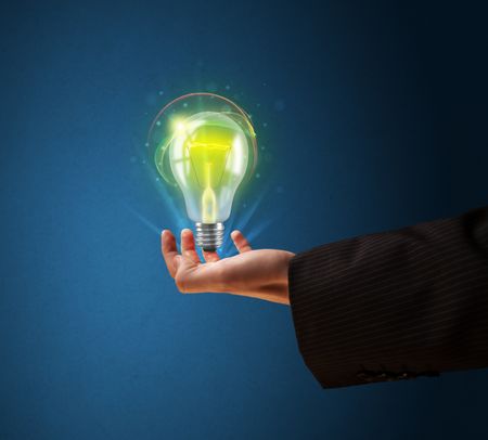 Businessman holding glowing lightbulb in his hand