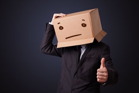 Businessman standing and gesturing with a cardboard box on his head with straight face