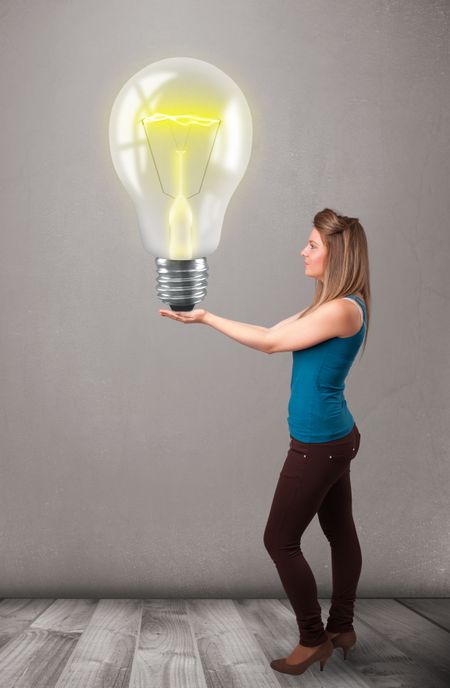 Beautiful young lady holding realistic 3d light bulb