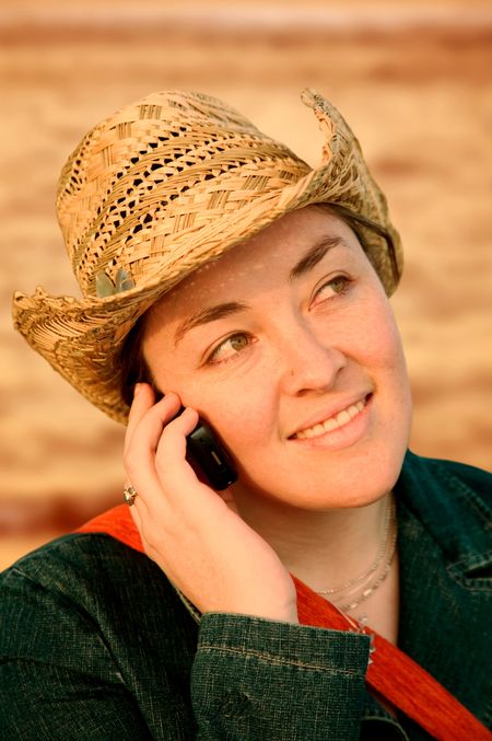 girl talking on a cellphone at sunset in front of the sea