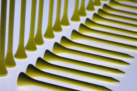 Yellow golf tees in two rows, one horizontal, one vertical, on reflective glass