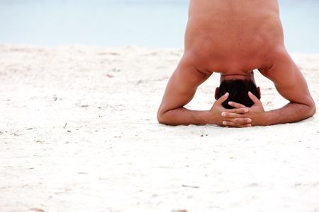 beach man doing yoga exercises in a tranquil location