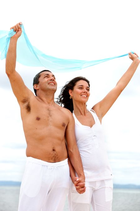 Beach couple with a sarong feeling the wind