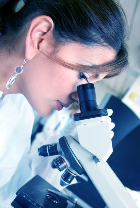 Doctor looking at samples under a microscope in a lab