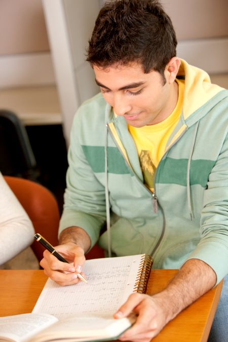 Man studying and writting on his notebook