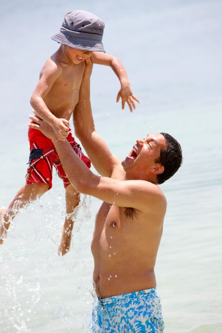 Man lifting his son playing at the beach