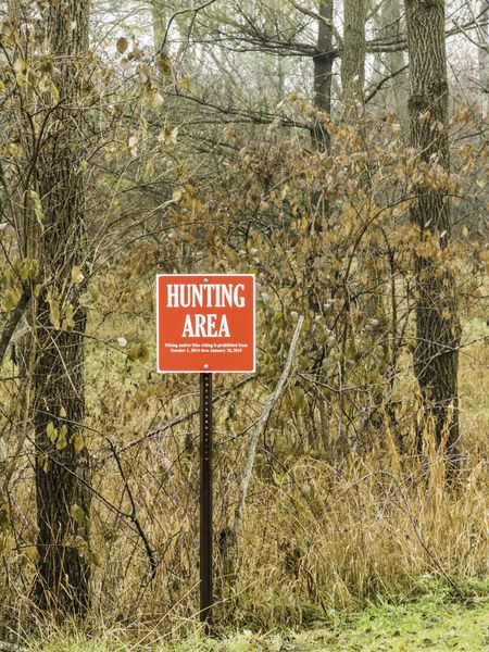 Warning notice for hikers and bikers: Red and white sign marks area for fall and early-winter hunting in a state park in northern Illinois, USA