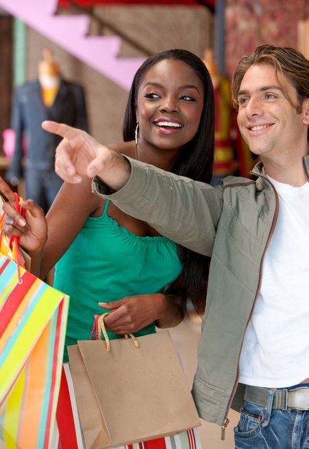 Multi-ethnic couple at a store pointing at something