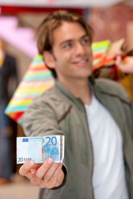 Shopping man showing a twenty euros bill