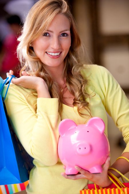 Shopping woman saving money in a piggy bank