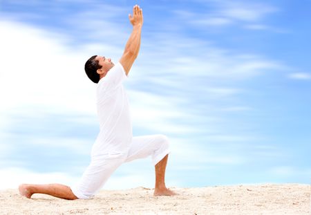 beach man doing yoga exercises in a tranquil location