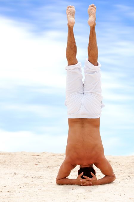 Fullbody man doing yoga on the beach