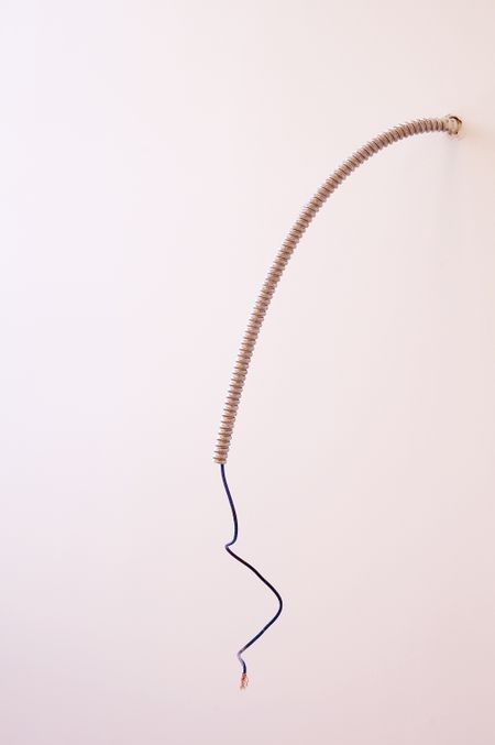 Electrical conduit and cable hanging from office wall