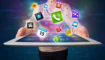 Young lady holding a tablet with modern colorful apps and icons